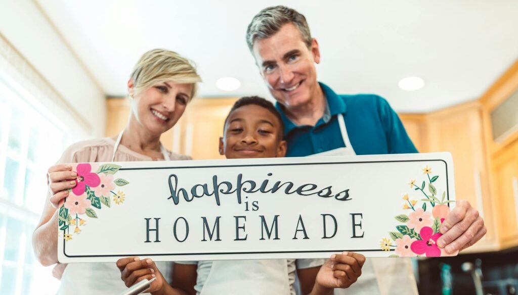 A joyful family in the kitchen holding a 'Happiness is Homemade' sign, embracing togetherness.